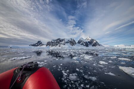 Part of red zodiac with icebergs landscape in Antarctica. Extreme travelling, sailing.