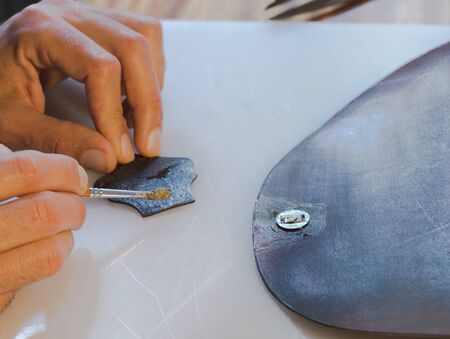 Handmade handicraft leather bag sewing process. Leather workshop glue smearの写真素材