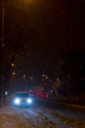 Winter snow storm.Night traffic jam . Car blurred at the street.の写真素材