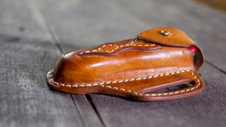 Handmade Leather Pancake Style Knife Sheath on wood background. Stitching by hand.の写真素材