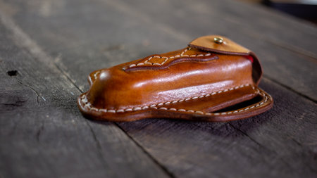 Handmade Leather Pancake Style Knife Sheath on wood background. Stitching by hand.の写真素材