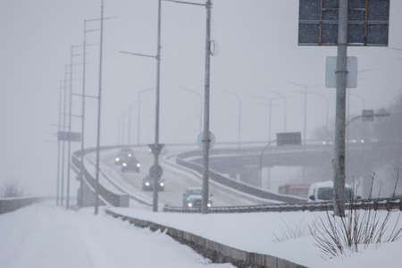 Snow roads in the city. Blizzard traffic, low visibility. Urban city storm. Kiev, Ukraine.の写真素材