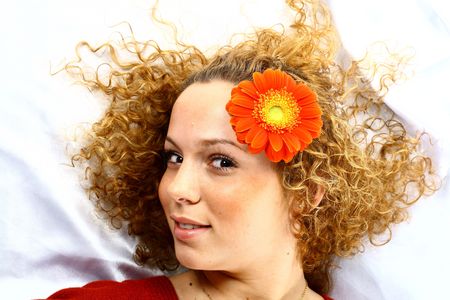 The beautiful girl lays red flowers in its hair are delightful smileの写真素材