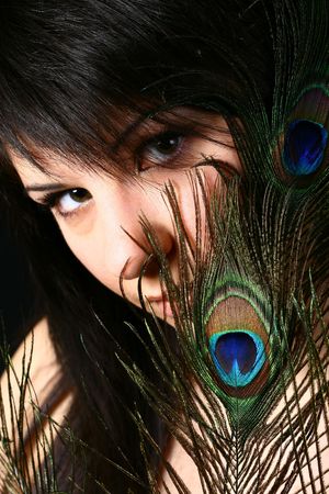 girl with a feather of the peacock looks at you glamourの写真素材