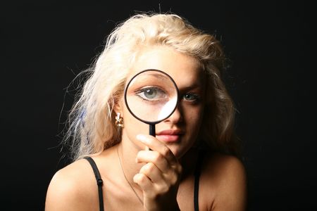 beautiful blondie girl with magnifier looka at youの写真素材