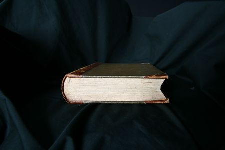 old book laying on black draperyの写真素材