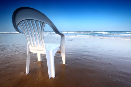 chair on sand and ocean backgroundの写真素材