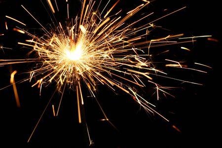 yellow sparkler holiday background on blackの写真素材