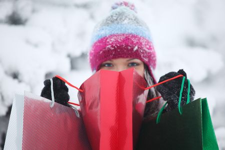 winter girl with gift bags on snow backgroundの写真素材