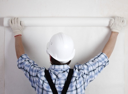 worker attaching wallpaper to wallの写真素材