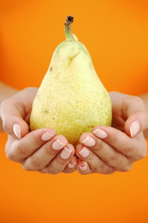 pear in woman hands close upの写真素材