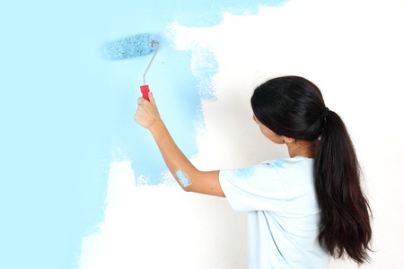 roller in woman hand paint on the wallの写真素材