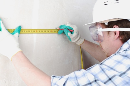 worker often with a measuring tape to the wallの写真素材