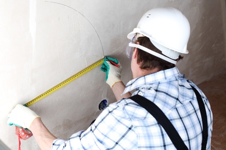 worker often with a measuring tape to the wallの写真素材