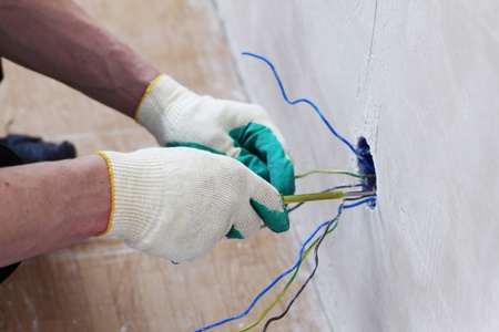 worker puts the wires in the wall