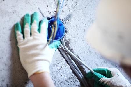 worker puts the wires in the wallの写真素材
