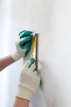 worker often with a measuring tape to the wallの写真素材