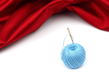 thread on red silk isolated close upの写真素材