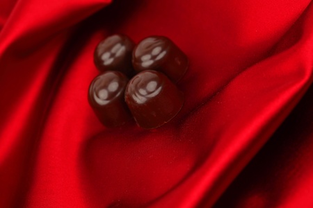 chocolate candy on red satin backgroundの写真素材