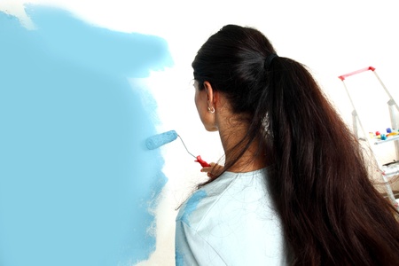roller in woman hand paint on the wallの写真素材