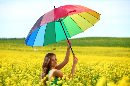 woman under umbrella on yellow flower fieldの写真素材