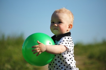  little boy play in green grass with green ballの写真素材