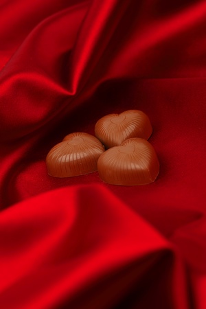 candy hearts on red satin backgroundの写真素材