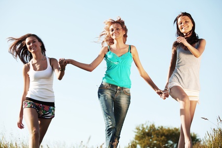 fun smile girlfriends run by green field sun is shineの写真素材