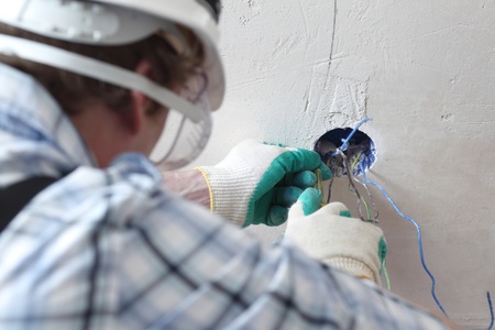 worker puts the wires in the wall