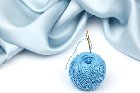 thread on blue silk isolated close upの写真素材