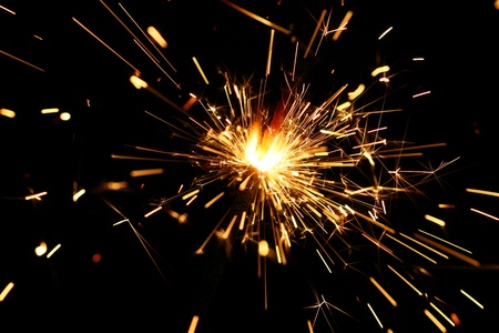 yellow sparkler holiday background on blackの写真素材