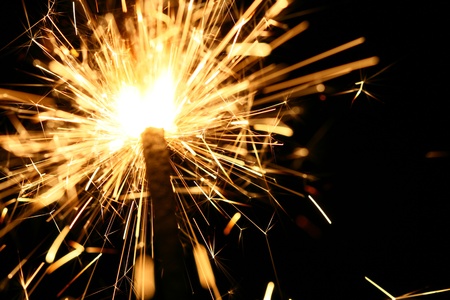yellow sparkler holiday background on blackの写真素材