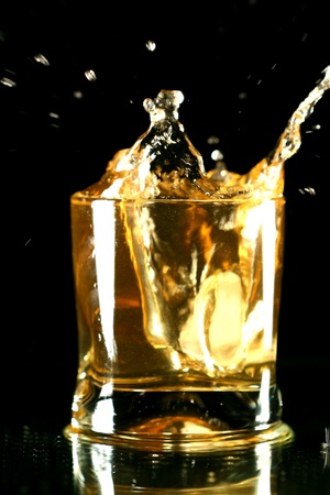 whiskey splash on black backgroundの写真素材