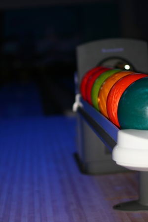 brightly lit up bowling balls in a rowの写真素材