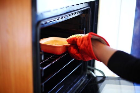 woman hand in gloves try to bake creme bruleeの写真素材