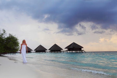 woman in a white dress on the ocean coastの写真素材