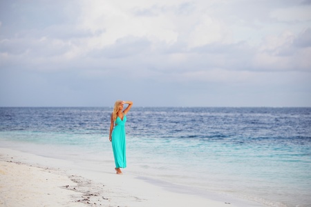 woman in a blue dress on the ocean coastの写真素材