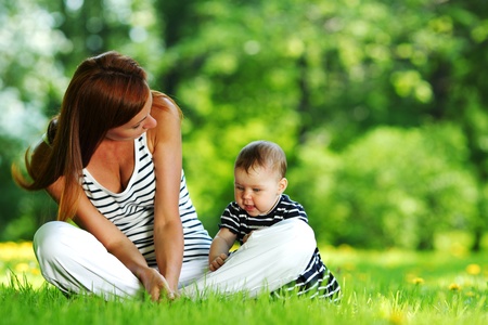 Happy mother and daughter on the green grassの写真素材