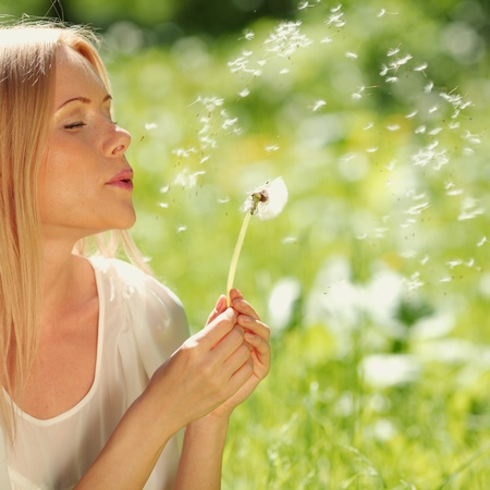 girl with a dandelion in his hand lying on the grassの写真素材