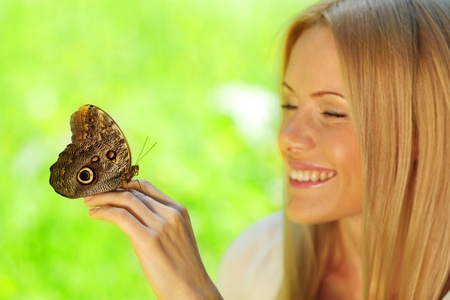 Woman playing with a butterfly on green grassの写真素材