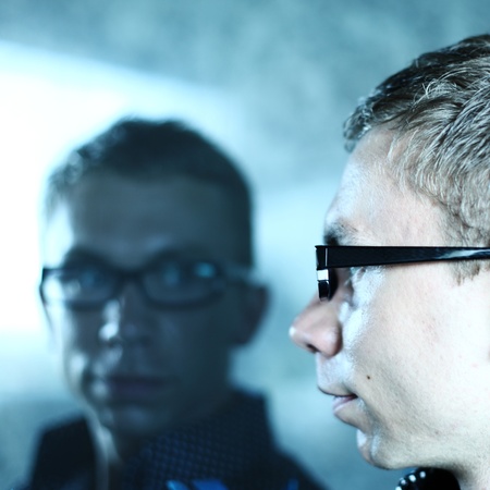 man and his reflection in glass