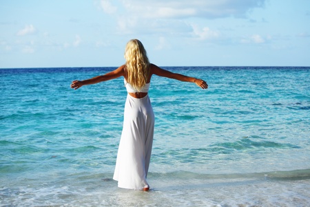 woman in a white dress on the ocean coastの写真素材