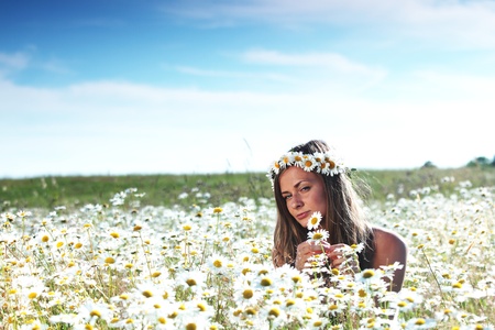 beautiful girl on the daisy flowers field の写真素材