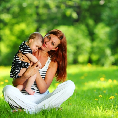 Happy mother and daughter on the green grassの写真素材