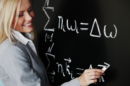 young woman teacher in front of a blackboardの写真素材