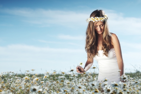 beautiful girl  in dress on the daisy flowers field の写真素材