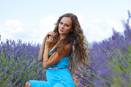 Woman sitting on a lavender fieldの写真素材