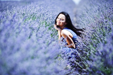 Woman sitting on a lavender fieldの写真素材
