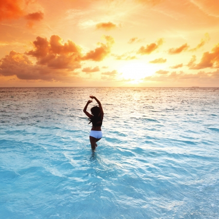 Young woman enjoy sunset in ocean waterの写真素材