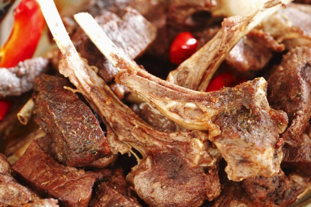 Appetizing roasted lamb ribs with tomatoes and pepper close-upの写真素材